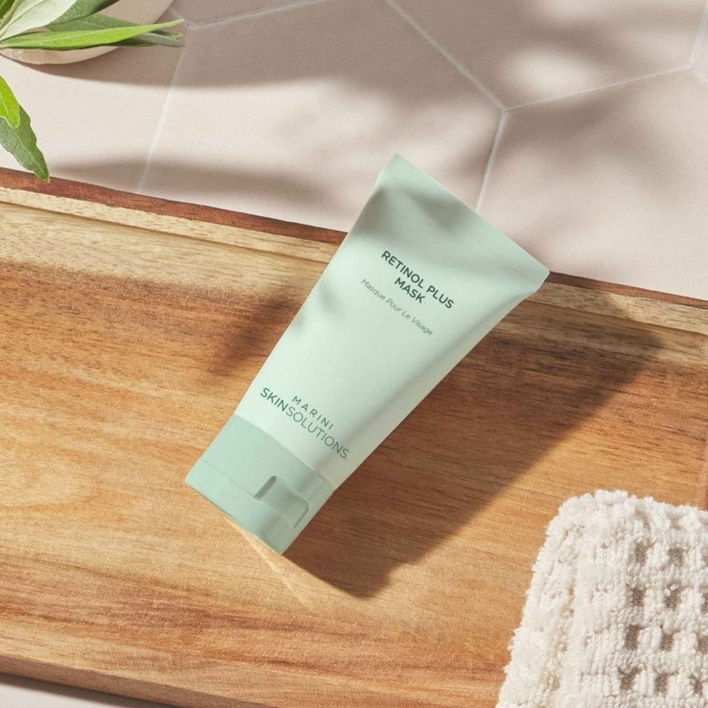 Marini SkinSolutions Retinol Plus Mask tube on a wooden surface with a neutral background