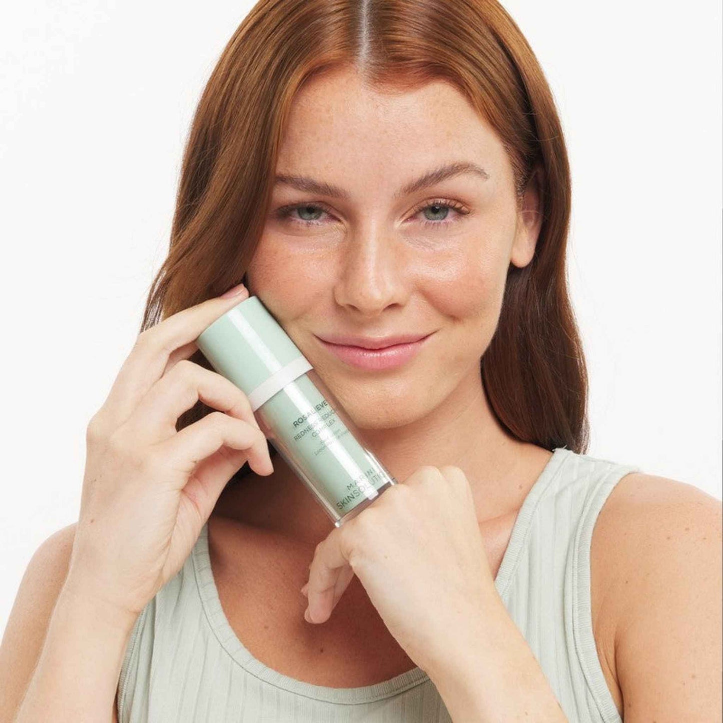Woman holding a Marini SkinSolutions Rosalieve against her face on a white background