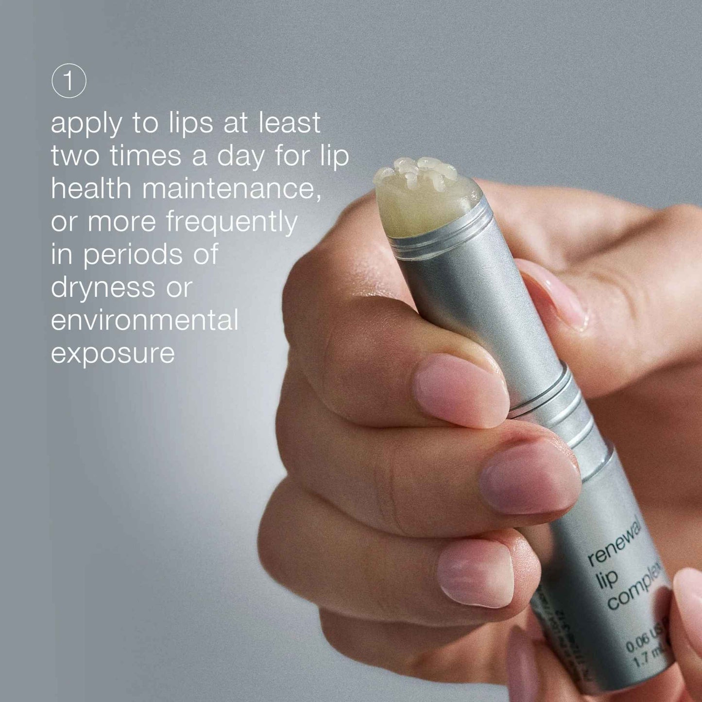 Hand holding dermalogica renewal lip complex with application instructions on a gray background