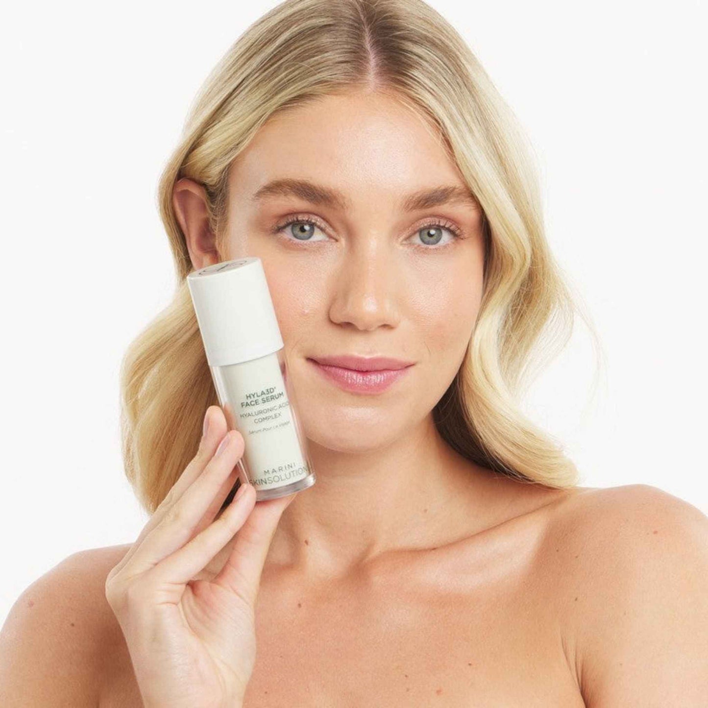 Woman holding a Marini SkinSolutions HYLA3D Face Serum against a white background